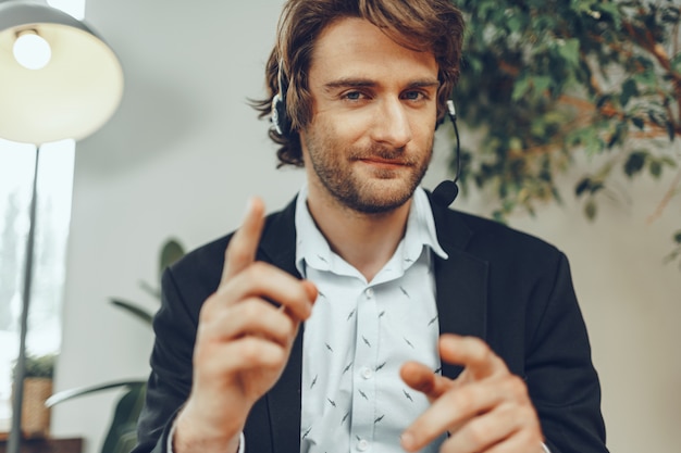 Homem de negócios barbudo com fone de ouvido conversando sobre negócios online