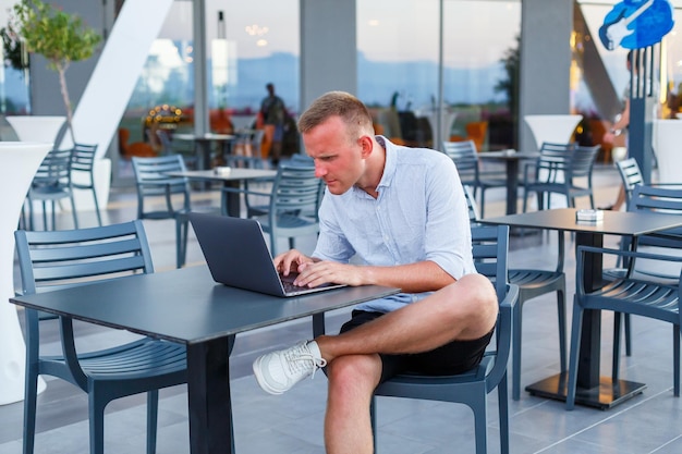 Homem de negócios bem sucedido freelance masculino usando o computador portátil no trabalho de férias. Negócios, estudo, freelance. Trabalho remoto