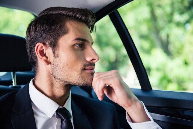 Homem de negócios bonito andando de carro