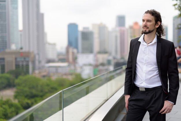 Homem de negócios bonito contra a vista da cidade de Bangkok, Tailândia