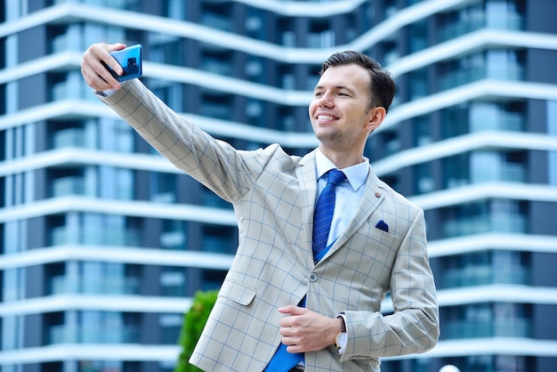 Homem de negócios bonito fazendo uma foto selfie no smartphone