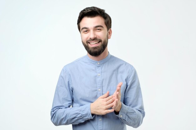 Homem de negócios bonito jovem com cara feliz sorrindo e olhando para a câmera