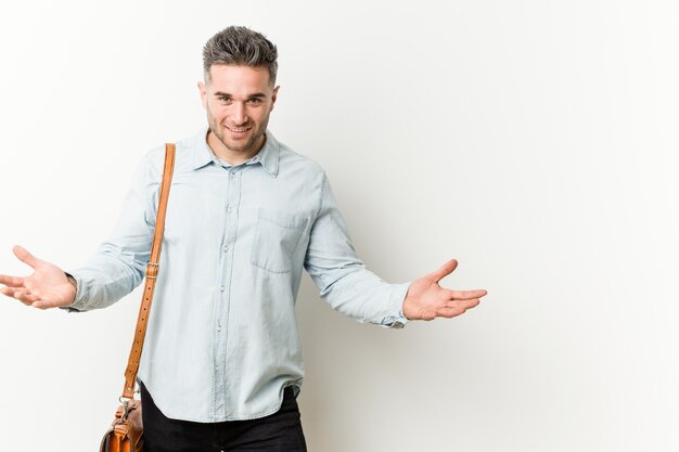 Homem de negócios bonito jovem mostrando uma expressão de boas-vindas.