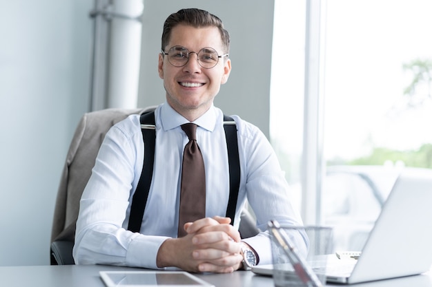 Homem de negócios bonito trabalhando com o laptop no escritório.