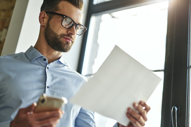 Homem de negócios calmo trabalhando com documentos no escritório