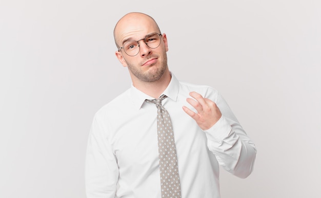 Homem de negócios careca parecendo arrogante, bem-sucedido, positivo e orgulhoso, apontando para si mesmo