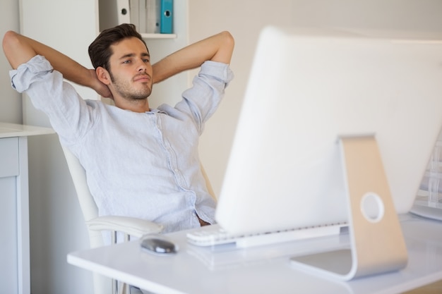 Homem de negócios casual relaxando na mesa inclinando-se para trás