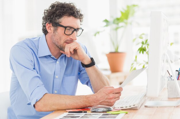 Homem de negócios casual usando o computador no escritório