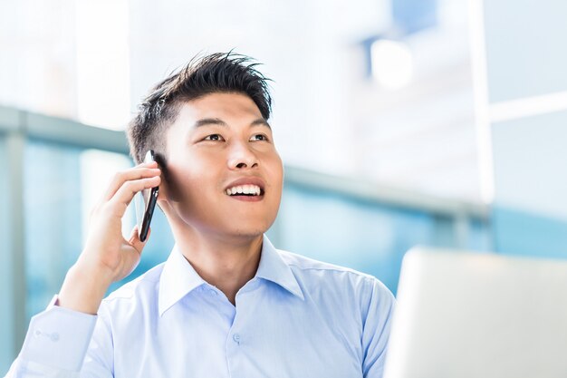 Homem de negócios chinês usando telefone