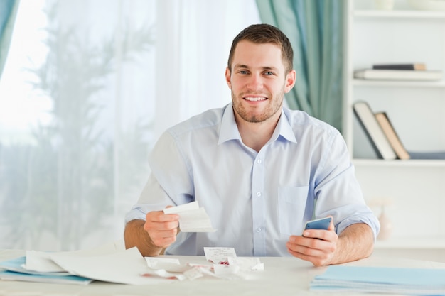 Homem de negócios com calculadora de bolso checando contas