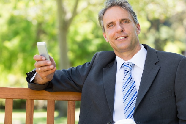 Homem de negócios com celular no parque