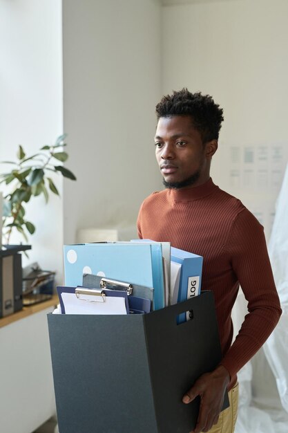 Homem de negócios com coisas a sair do escritório.