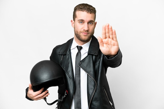 Homem de negócios com um capacete de moto sobre fundo branco isolado, fazendo o gesto de parada