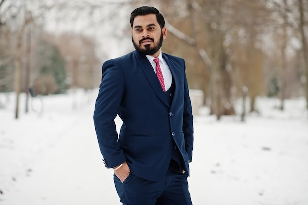 Homem de negócios de barba indiana elegante de terno posou no dia de inverno ao ar livre