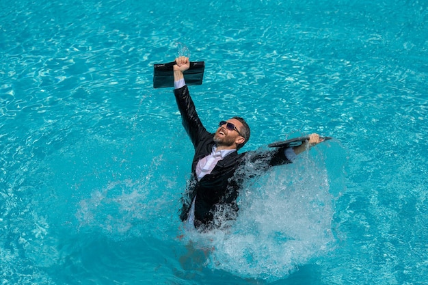 Foto homem de negócios de fato e portátil salpicando água na piscina louco verão férias de negócios engraçado