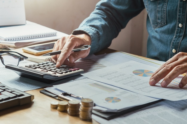 homem de negócios de mão usando calculadora para calcular de contabilidade de finanças de documento de dados