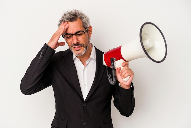 Homem de negócios de meia-idade segurando um megafone isolado no fundo branco chocado, ela se lembrou de uma reunião importante