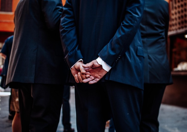 Homem de negócios de pé com as mãos atrás das costas