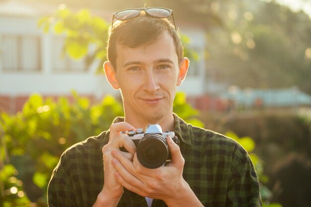 Homem de negócios de surfista freelancer feliz com câmera relaxante na praia. freelance e trabalho remoto. feliz fotógrafo masculino freelancing e surf nas férias de verão no mar