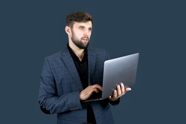 Homem de negócios de terno azul segurando um laptop