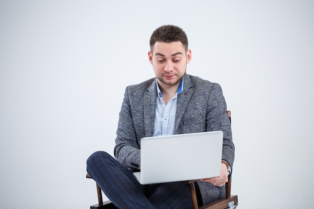 Homem de negócios diretor professor sentado em uma cadeira estudando documentos. Ele está olhando para a tela do laptop. Novo projeto de negócios.