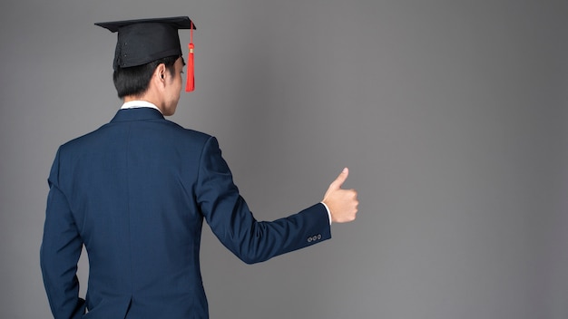 Homem de negócios está segurando o chapéu de formatura, conceito de educação de negócios