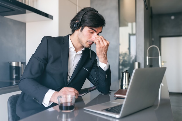 Homem de negócios estressado com fadiga visual devido ao uso de display