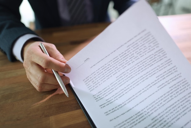 Foto homem de negócios examina atentamente as disposições do contrato