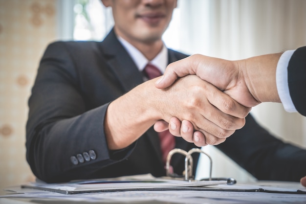 Homem de negócios feliz com aperto de mão de confiança com o parceiro