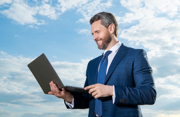 homem de negócios feliz freelancer ao ar livre homem de negócios freelancer com laptop vestindo terno foto de homem de negócios freelancing homem de negócio freelancer no fundo do céu