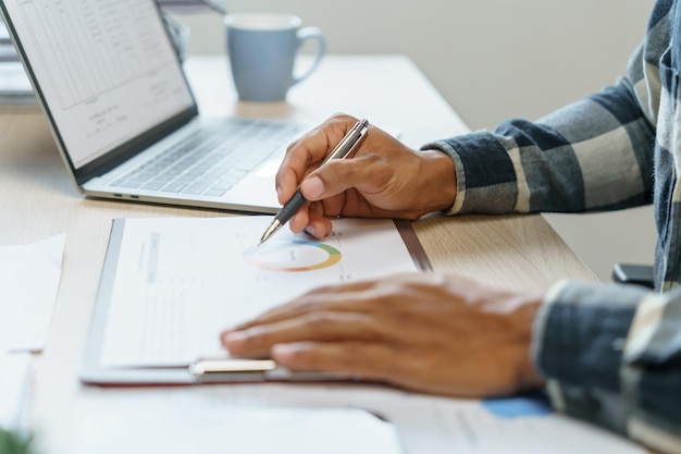 Homem de negócios hispânico confiante e atraente usando computador portátil e investidor profissional inicia o planejamento de negócios do projeto no escritório