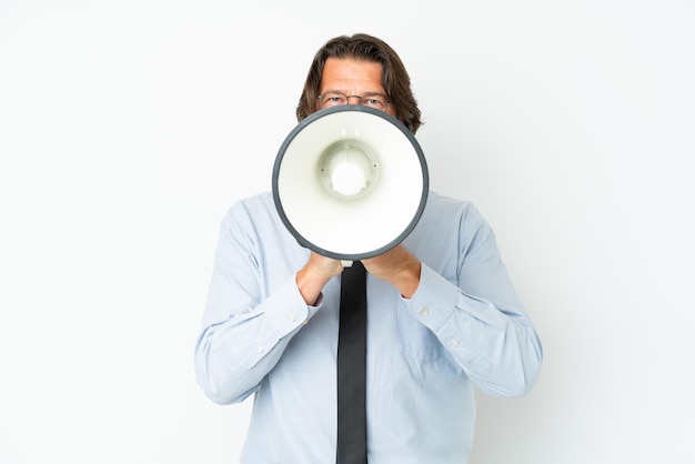 Homem de negócios holandês sênior isolado no fundo branco gritando através de um megafone