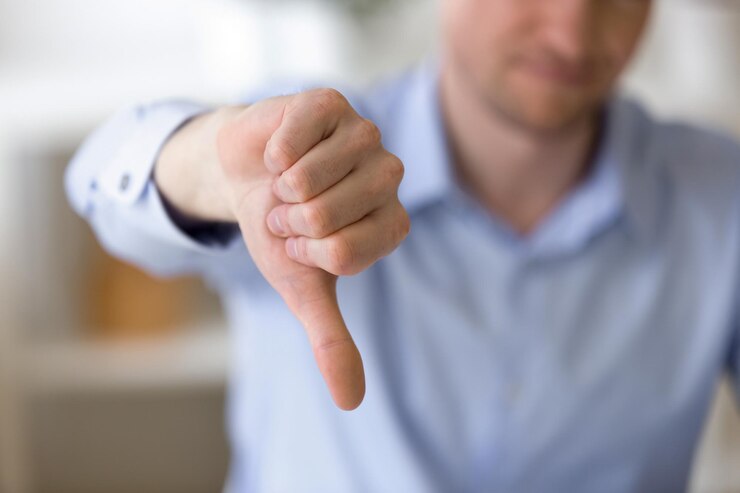 Foto homem de negócios insatisfeito mostrando o polegar para baixo no local de trabalho
