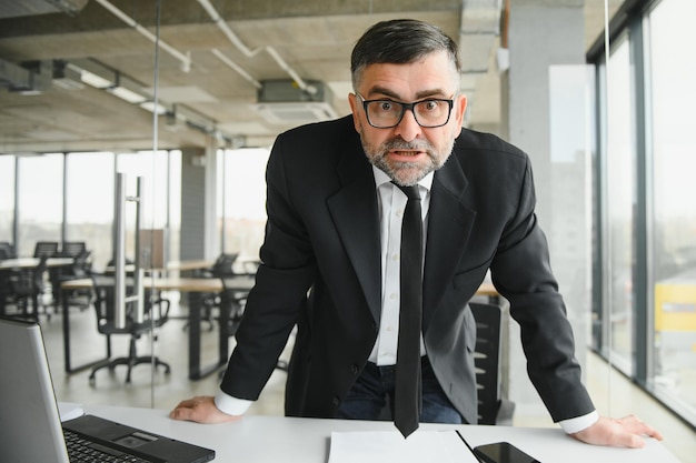 Foto homem de negócios irritado sentado à mesa e gritando