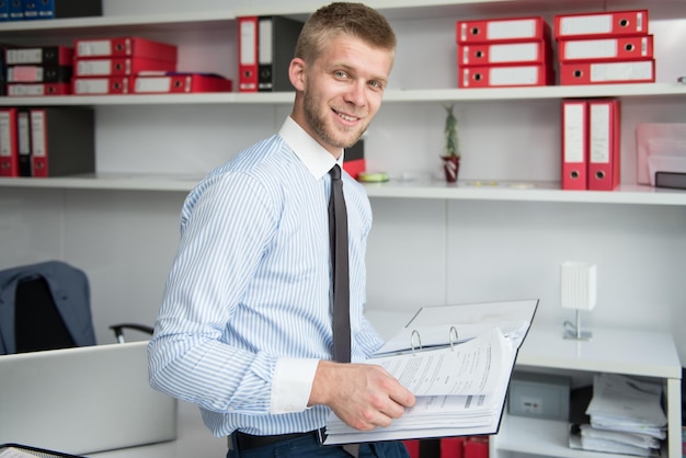 Foto homem de negócios jovem feliz trabalhar no escritório moderno em papéis