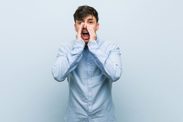 Homem de negócios latino-americanos jovens gritando animado para a frente.