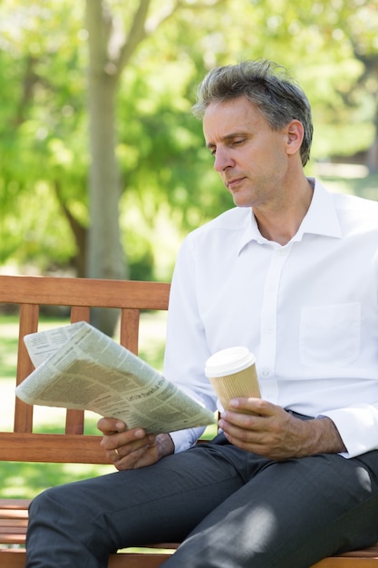 Foto homem de negócios lendo jornal no parque