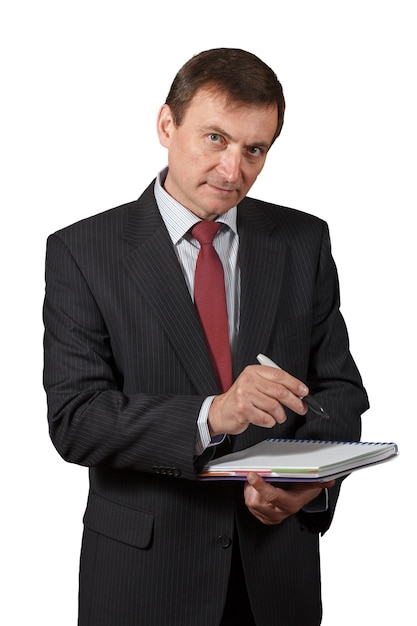 Homem de negócios maduro bonito, confiante e amigável, segurando um marcador e escrevendo em um caderno sobre fundo branco isolado
