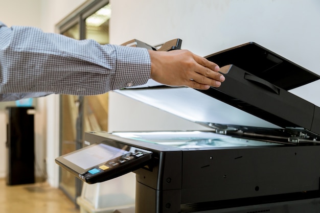 Foto homem de negócios mão pressione o botão no painel da impressora, impressora scanner de laser de escritório máquina de cópia suprimentos começar