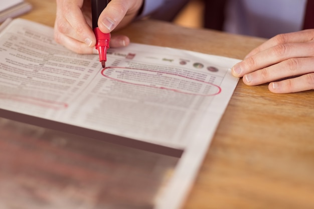 Homem de negócios marcando o jornal com marcador