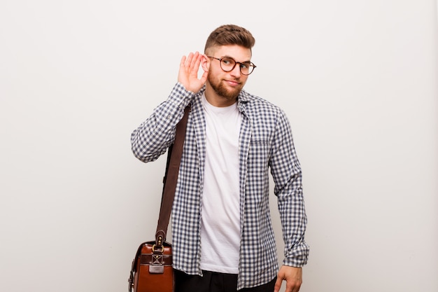 Homem de negócios moderno jovem tentando ouvir uma fofoca.