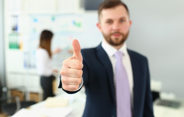 Foto homem de negócios mostrando o polegar para cima sinal de sucesso sobre a equipe difusa de pessoas de negócios