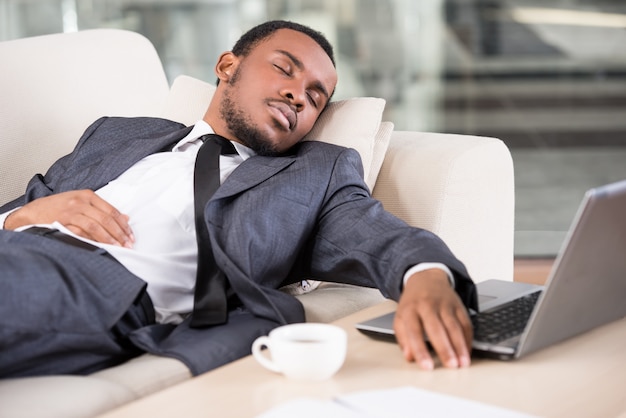 Homem de negócios na África está segurando a mão no laptop