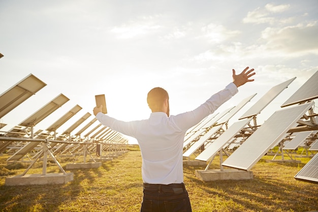 Foto homem de negócios no campo com painéis solares