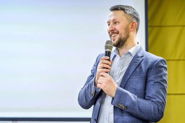 Homem de negócios novo na sala de conferências do negócio com público que dá apresentações. audiência na sala de conferências. clube de empreendedorismo