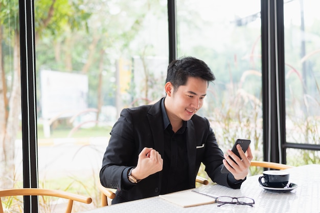 Homem de negócios olhando o celular e feliz