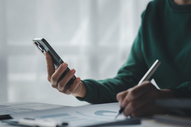 Homem de negócios olhando para informações financeiras de um telefone celular ele está verificando documentos financeiros da empresa ele é um executivo de uma empresa startup Conceito de gestão financeira