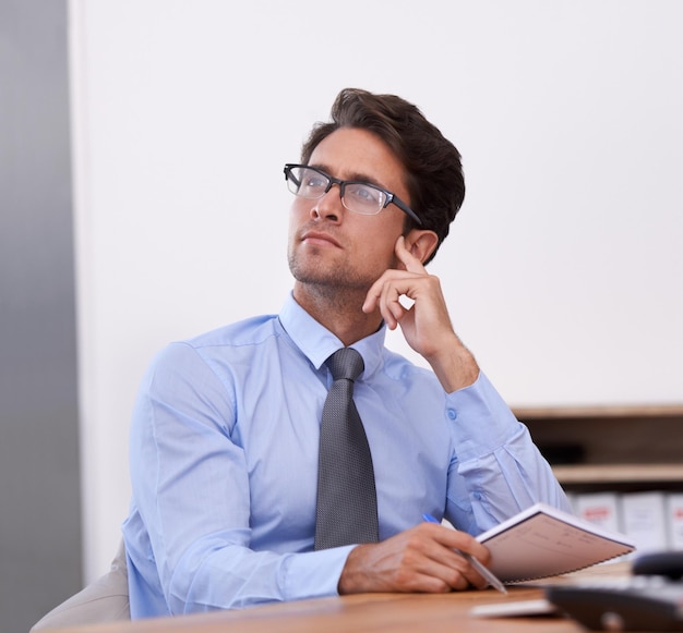 Foto homem de negócios pensando e ideias em caderno contemplando o futuro da empresa e anotações no local de trabalho planejamento profissional masculino e agenda para cronograma ou estratégia diário e solução ou informação