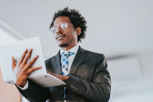 Homem de negócios profissional usando seu laptop enquanto trabalhava em um escritório moderno. conceito de negócios e tecnologia.