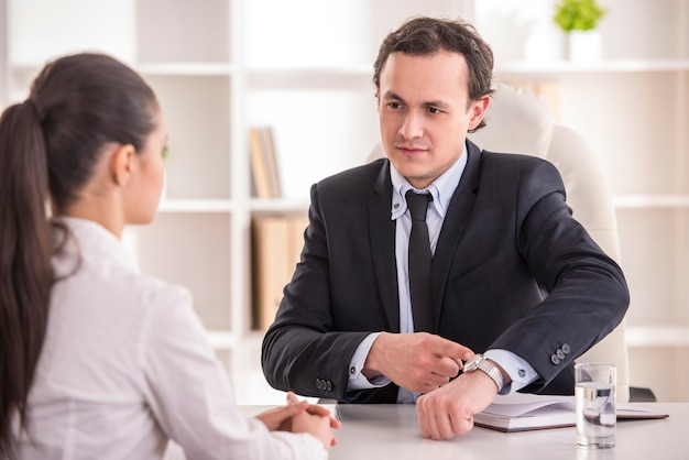 Homem de negócios que entrevista o candidato fêmea para o trabalho no escritório.